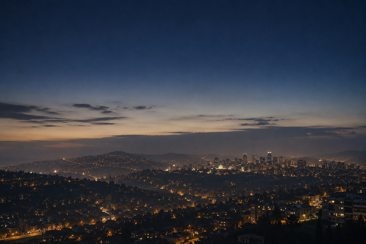 The hills of Kigali at dusk, scattered with warm city lights under a deep indigo sky